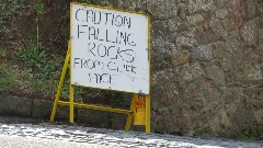 sign Caution Falling Rocks from Cliff Face