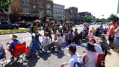 4th of July parade; firemen high fiving kids along the parade route